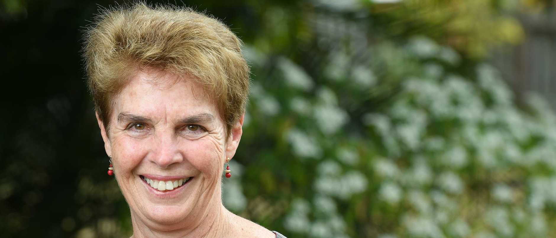 Kaye Basford standing infront of a green background