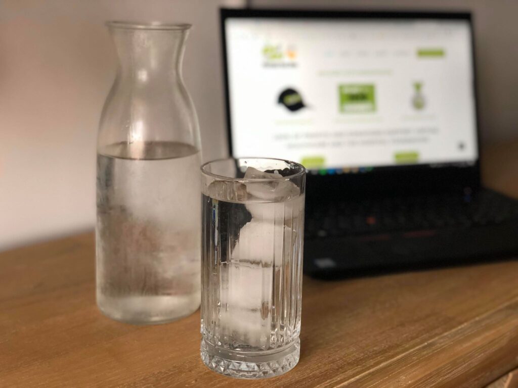 Glass of water with ice and a jug